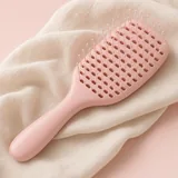 Illustration of a pink detangling hair brush on a cream towel