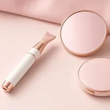 Illustration of a white and rose gold heated eyelash curler wand next to pink compacts