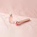 Illustration of a rose gold handheld red light facial wand beside a serum bottle on pink marble